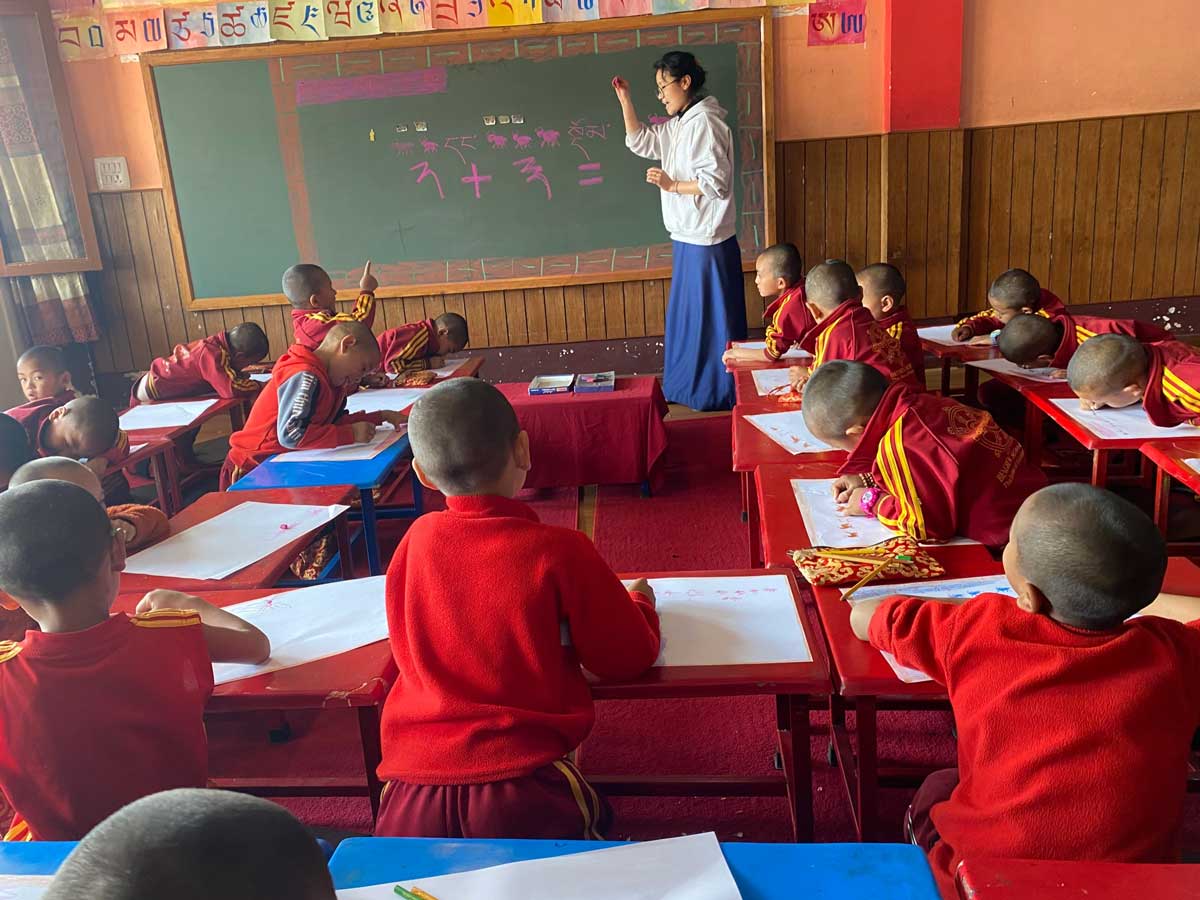 Schüler der 1. Klasse lernen spielerisch das kleine Einmaleins auf Tibetisch mit ihrer Lehrerin Tsering Dolma, in einem der bereits entsprechend der Waldorfpädagogik umgebauten Klassenräume